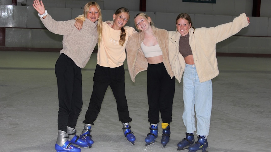 four teenage girls at an ice rink