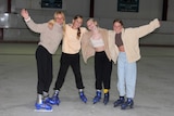 four teenage girls at an ice rink