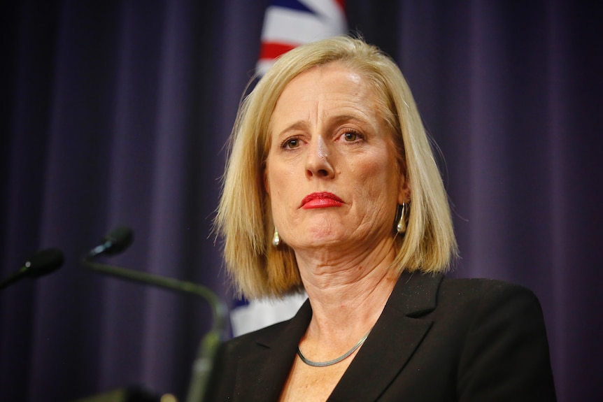 Gallagher looking serious as she stares off camera inside the Parliament House "blue room".