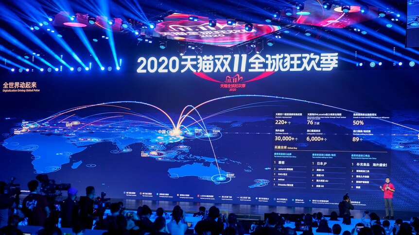 A huge blue video wall displays data about global shopping transactions in Chinese characters and Hindu-Arabic numerals.