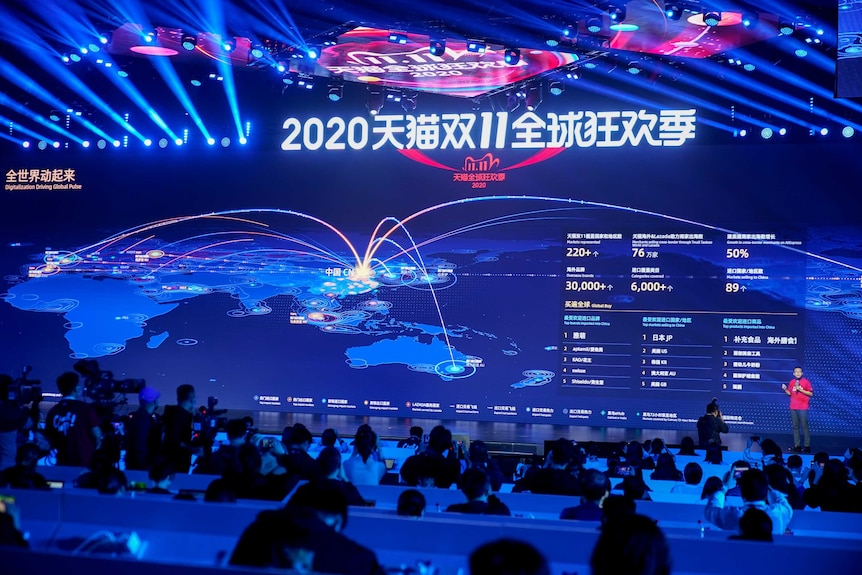 A huge blue video wall displays data about global shopping transactions in Chinese characters and Hindu-Arabic numerals.