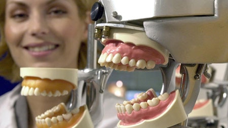 A woman look at sets of teeth at the International Dental Show in Cologne in 2001.