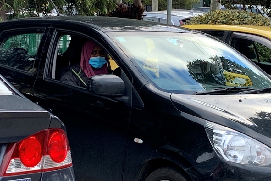 A woman inside a black car.