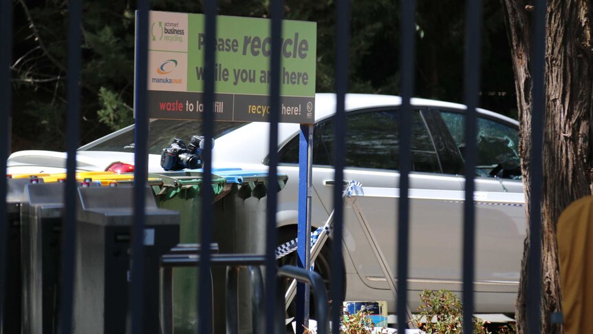A car with police tape on it behind the gates at Manuka Oval in Canberra.