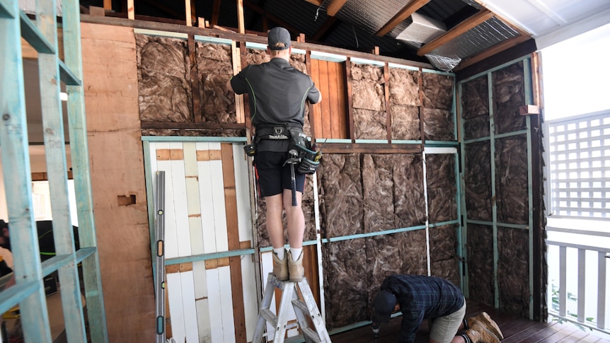 Two unidentifiable people work on a home renovation in Brisbane.