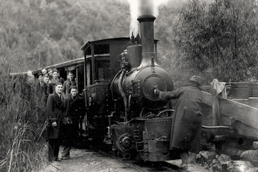Footballers hang off the side of a steam train for a photo