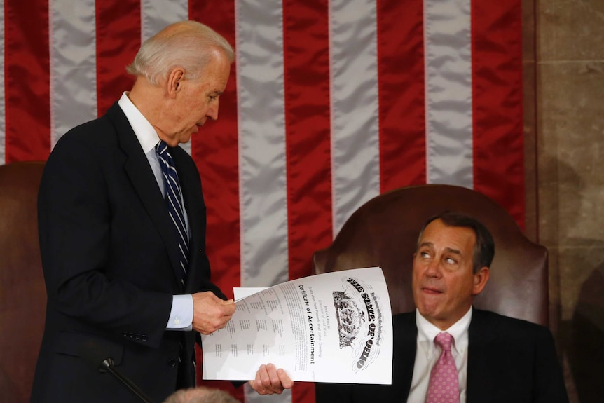 US Vice President Joe Biden (L) holds the presidential election electoral college vote certificate.