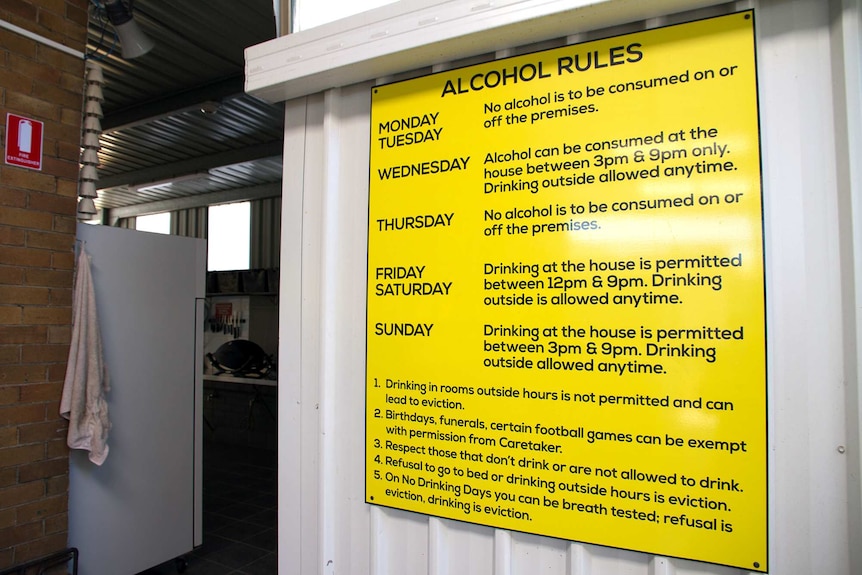 A large yellow sign with black writing spells out rules for drinking