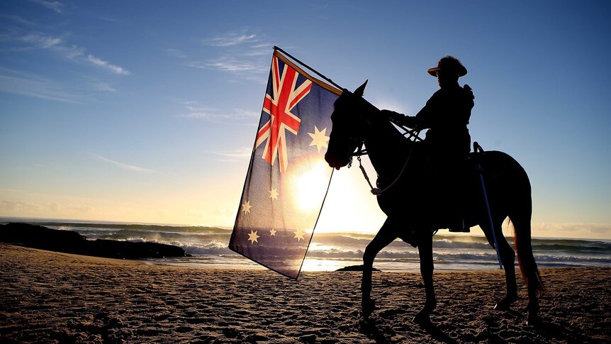 A member of the Mudgeeraba light horse troop takes part in the Anzac Day dawn service at Currumbin.