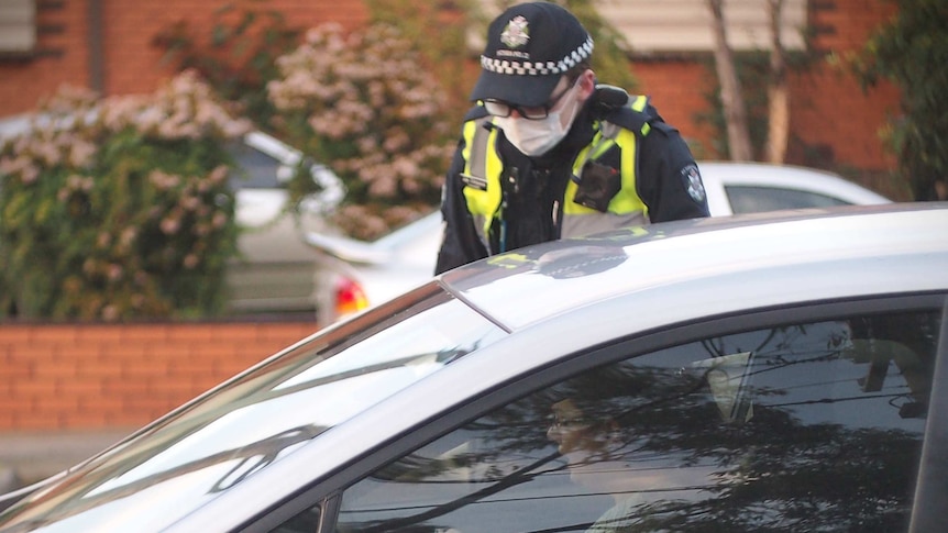 A police officer checks a driver's identification.