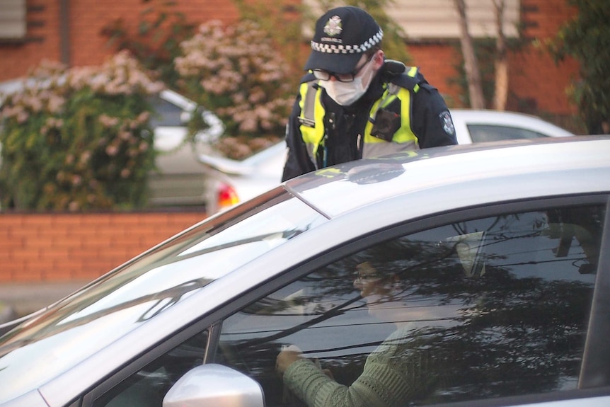 A police officer checks a driver's identification.