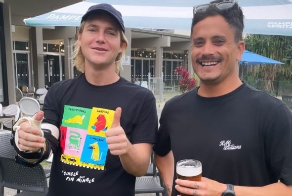 Joe and friend standing smiling at pub