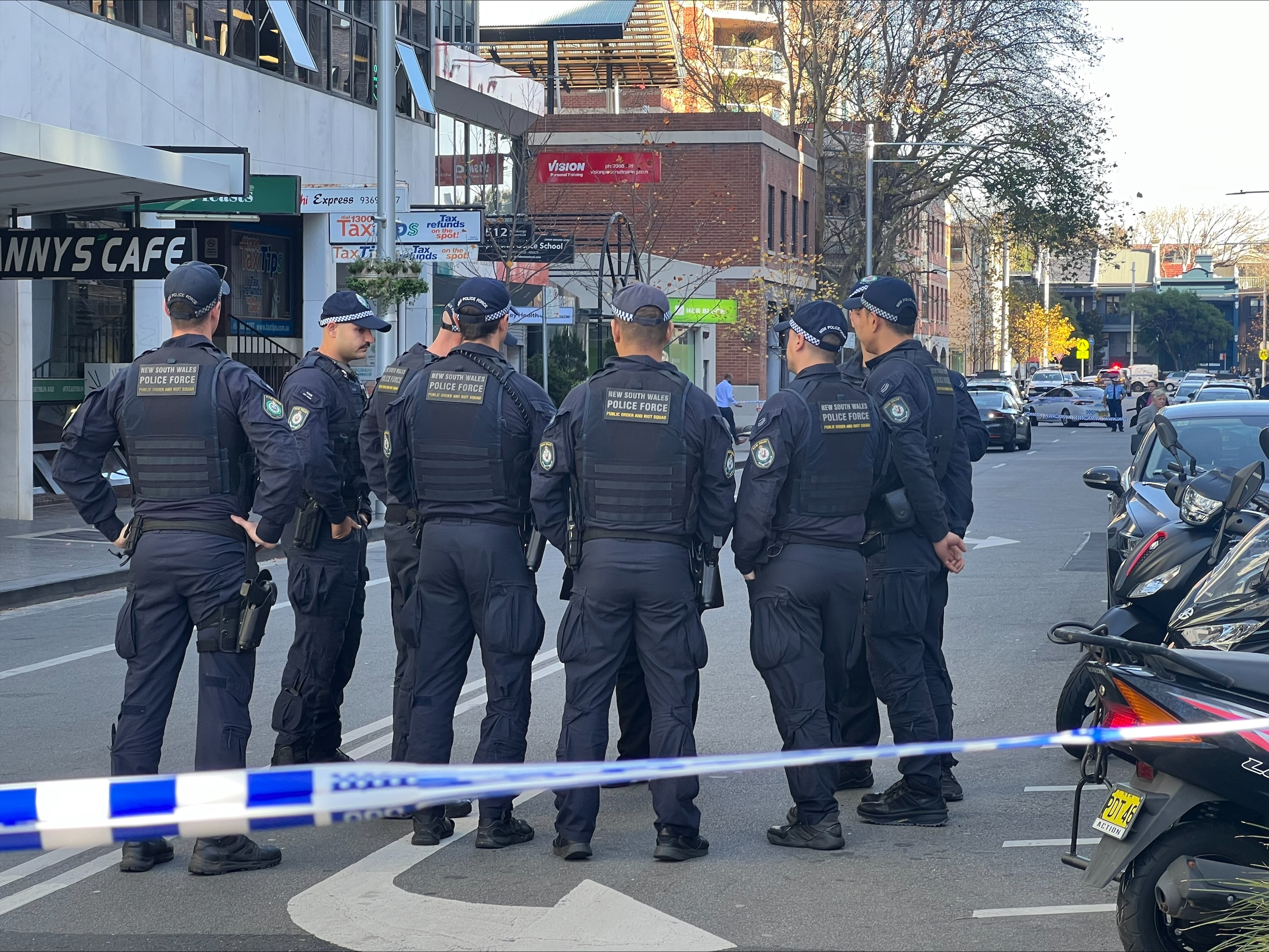 A group of heavily armoured police officers standing on a street