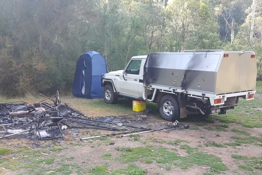 le camping brûle, avec tente brûlée, chaises et autres équipements de camping.  ute avec des dommages d'incendie mineurs.