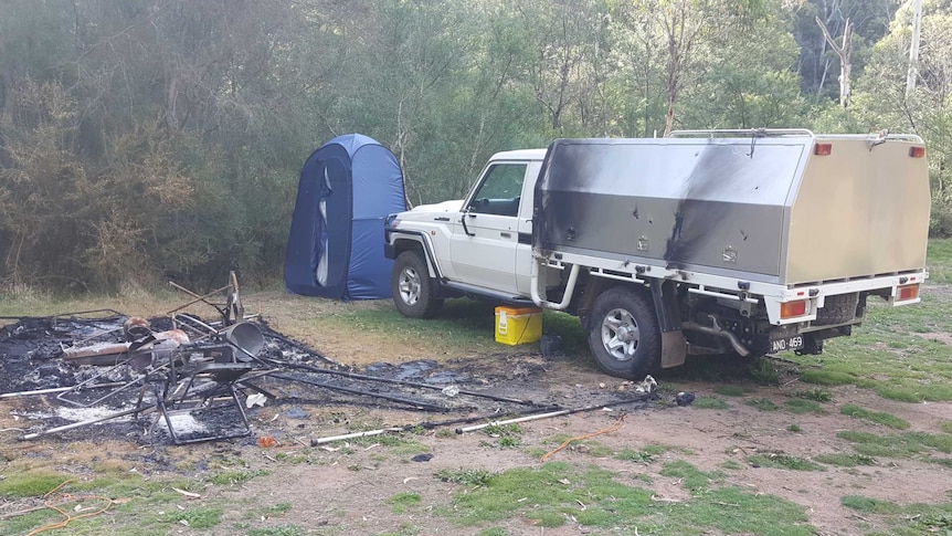 Camp site burn out, with burnt tent, chairs and other camping equipment. ute with minor fire damage.