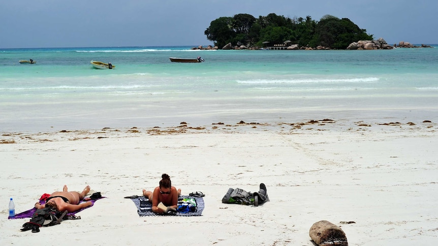 Tourists lying on a Seychelles beach