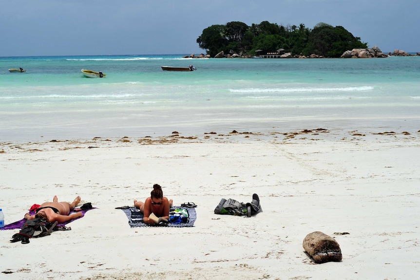 Tourists lying on a Seychelles beach
