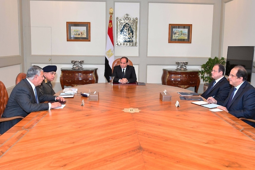 Abdel-Fattah al-Sisi, centre, meeting with officials in a board room.