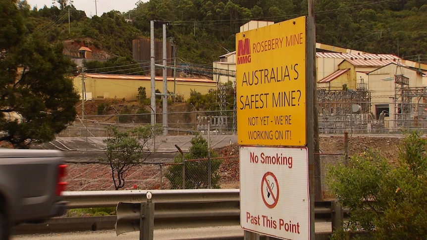 A sign outside a complex of mine buildings that says 'MMG Rosebery Mine. Australia's Safest Mine?'
