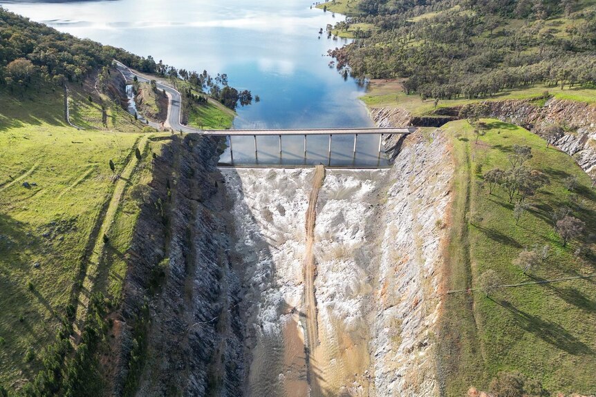A view from above of a large dam spilling over.