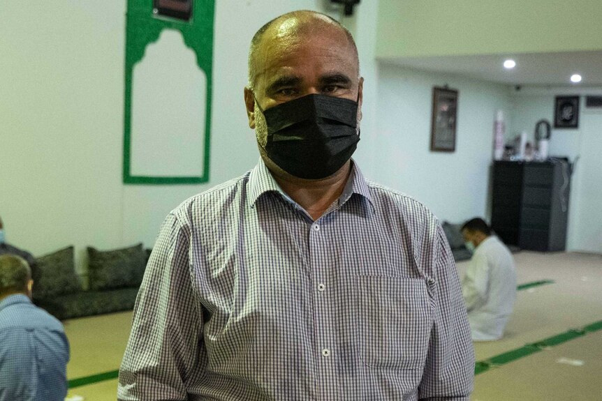 Middle aged man with bald head wears mask