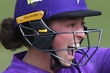 A Hobart Hurricanes WBBL wicketkeeper yells out after she holds up her left glove.