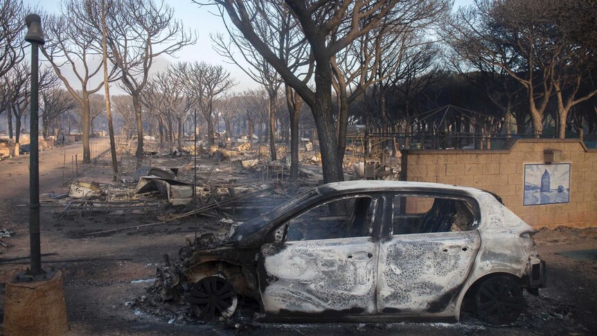 The charred remains of a car lies in campsite near Mazagon in southern Spain.