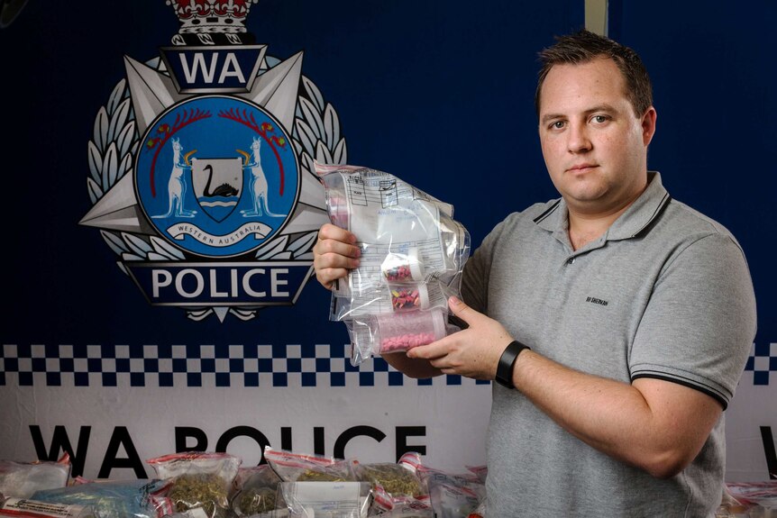 A policeman holds up some of the drugs seized.