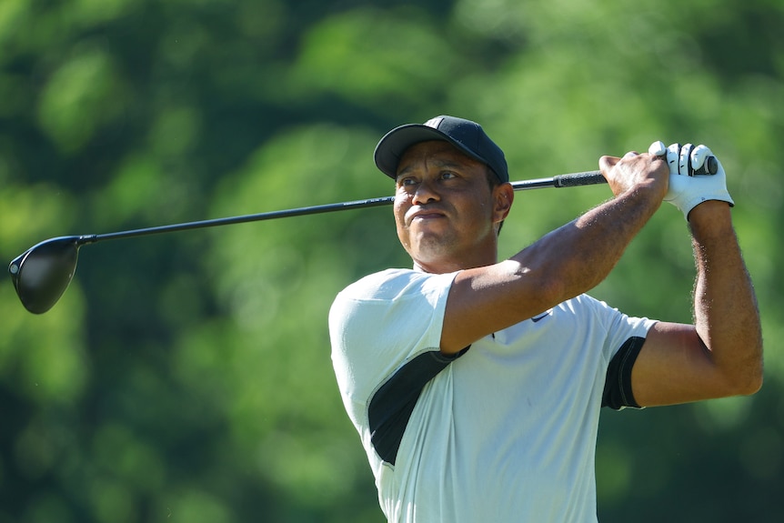 Tiger Woods looks ahead as he completes a swing with his driver
