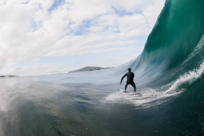 First person view of surfing in a barrel