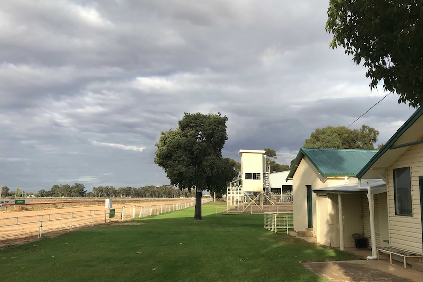 A number of buildings by the side of a country racetrack.