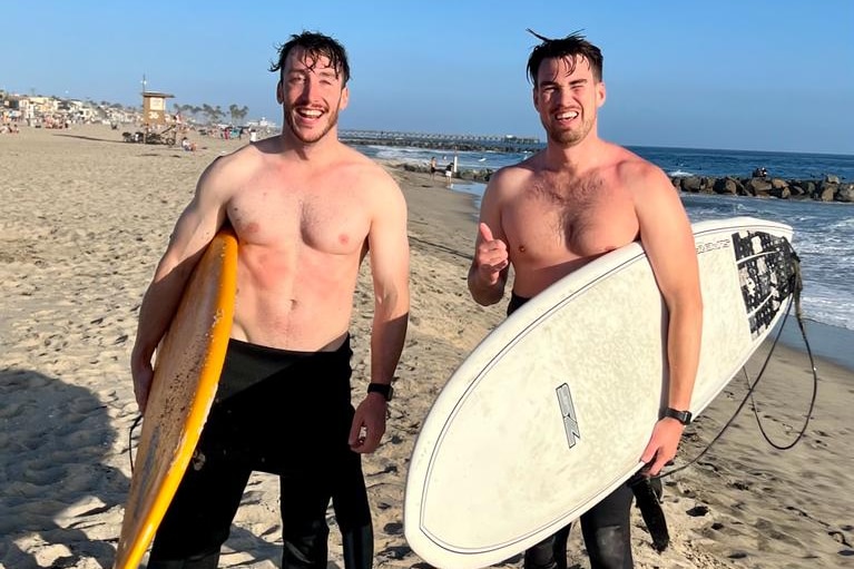 two boys at the beach with their surfboard