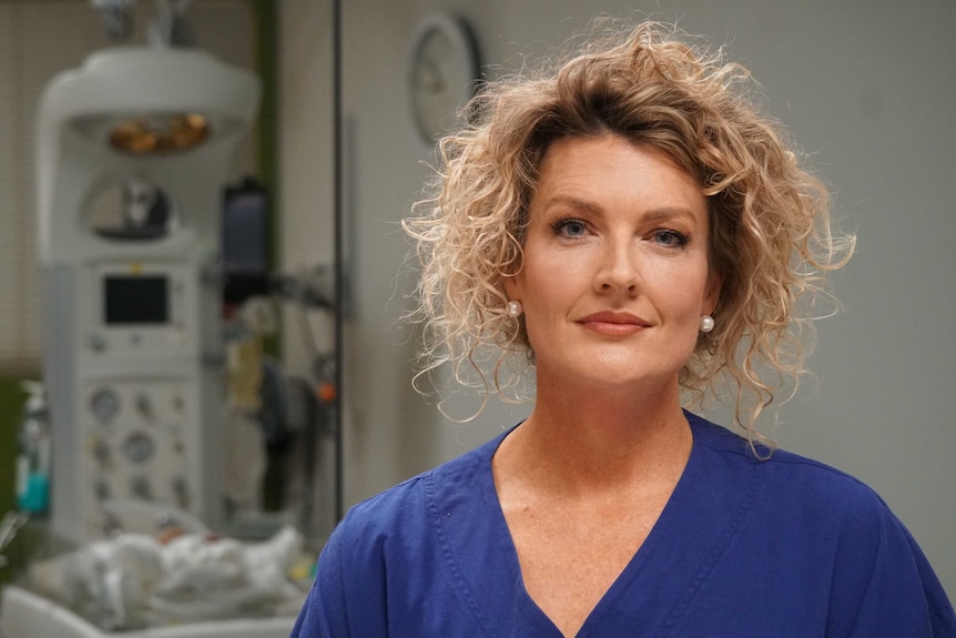 A woman in a nursing uniform in a hospital.