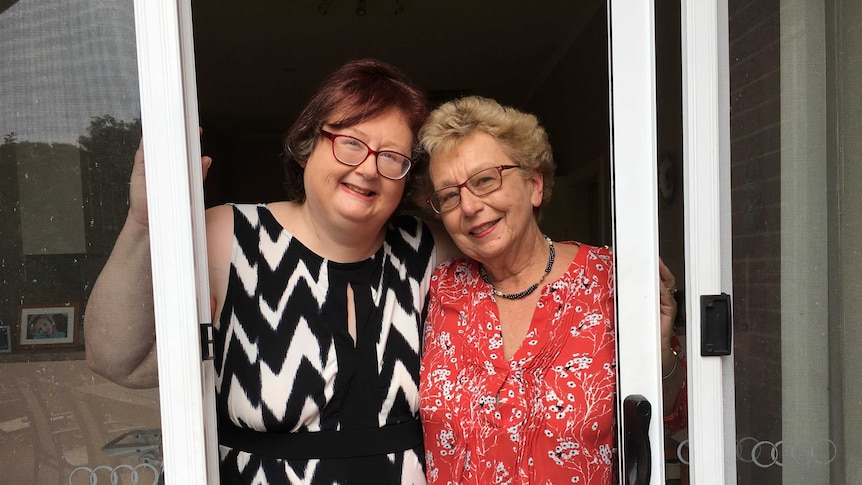 Two women smile at the camera.