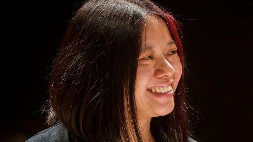 Composer Liza Lim looks slightly to the right and smiles at someone off-camera.
