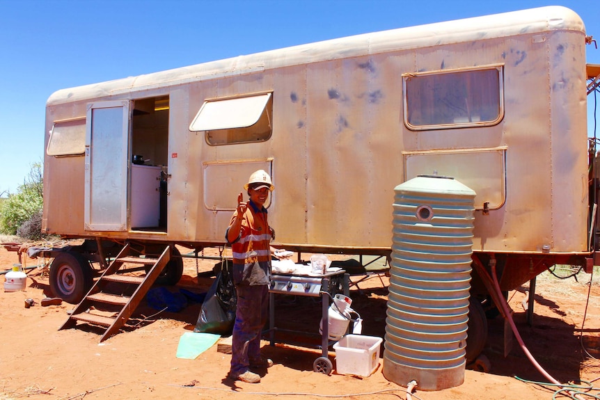 A mid-shot of a silver caravan in the desert