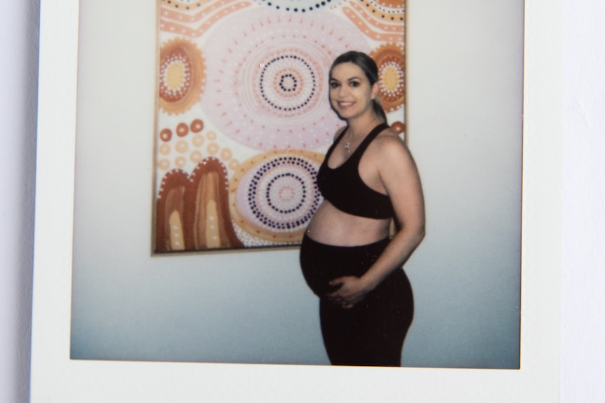 A picture of a photo of a woman showing her belly at 32 weeks pregnant.