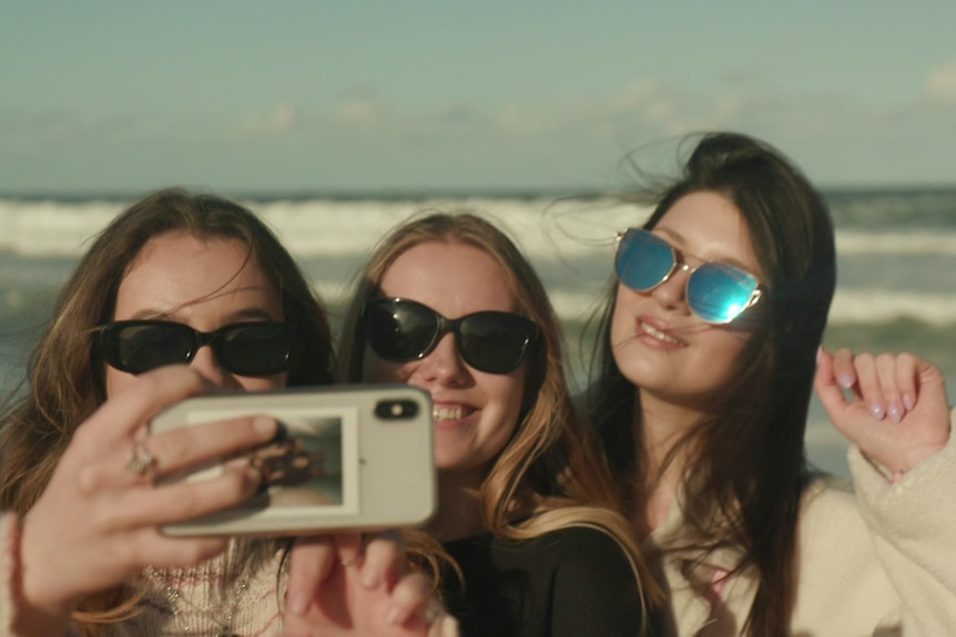 Drei ukrainische Tanzstudentinnen machen gemeinsam ein Selfie an einem Strand in Sydney