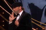 Deaf actor Troy Kotsur gestures with finger guns at the BAFTA awards as he talks about a possible deaf James Bond