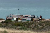 Emergency service vehicles parked by the coast.