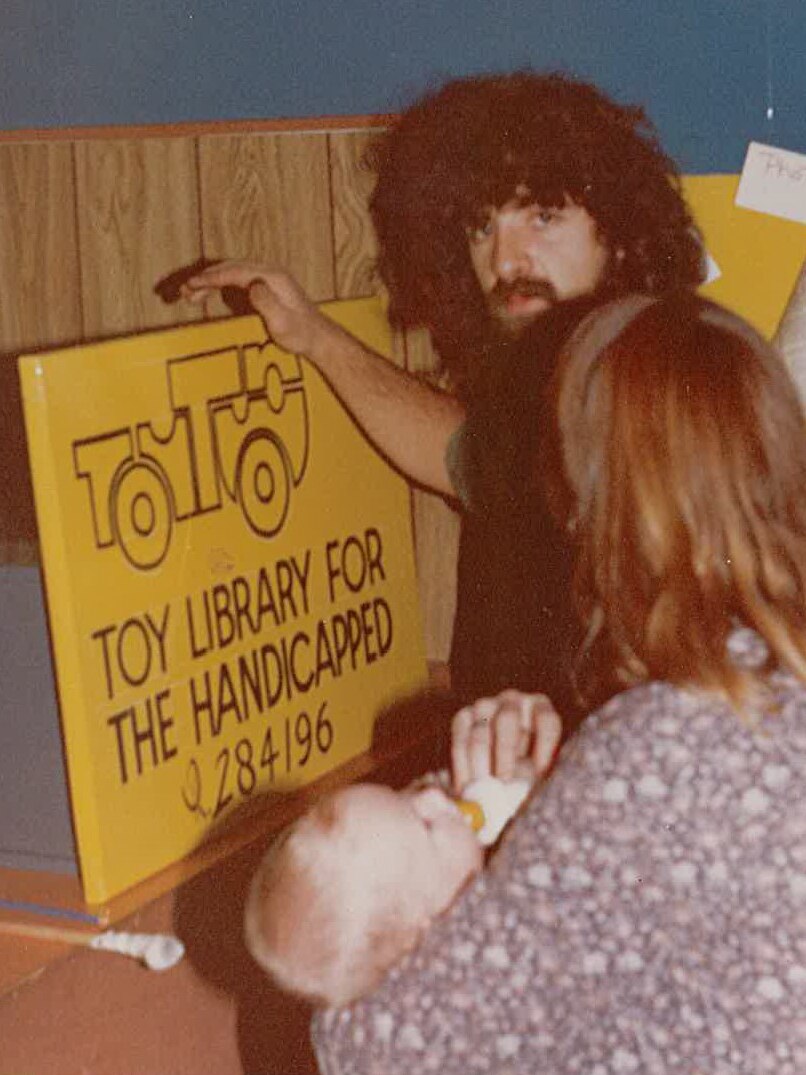 Couple looking at toy library sign.