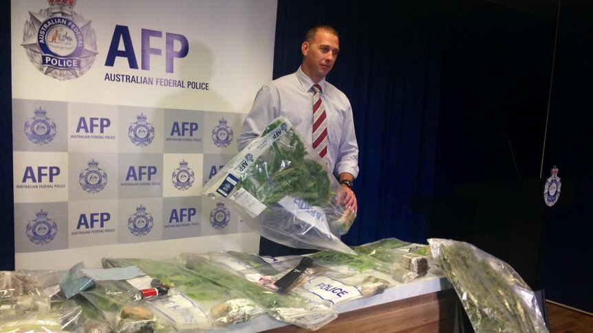 Detective Sergeant Shane Scott with cannabis plants seized from the Richardson home.