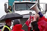 Coles employees stop a truck at the picket line.