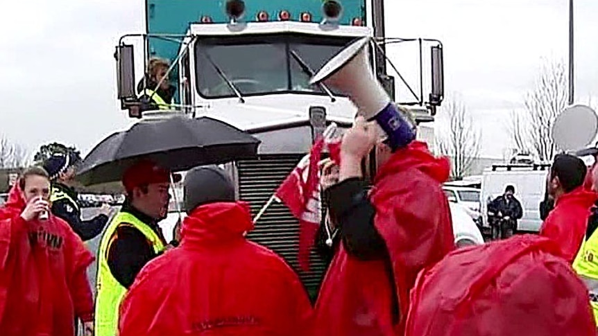 Coles employees stop a truck at the picket line.