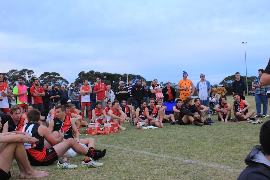 A large group of people sitting and standing on a football oval for Boxwood Hill Football Club's Big Freeze event.