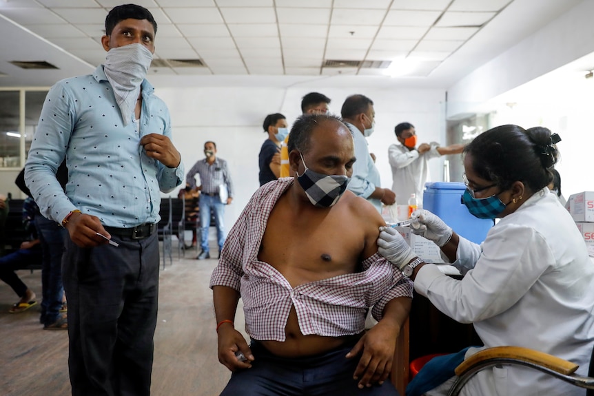 A man gets an injection in a hospital. 