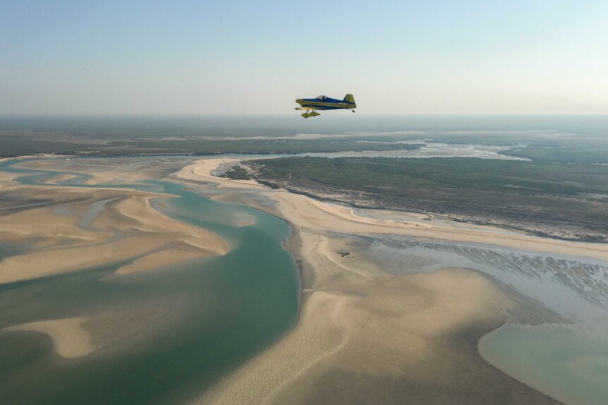 David Foord's aerobatic plane flies over Willie Creek, north of Broome.