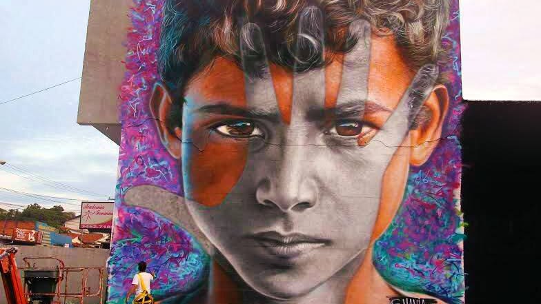 A colourful mural shows a young boy with a black and white handprint covering his face.