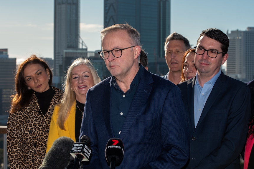 Anthony Albanese flanqueado por parlamentarios laboristas mientras habla en Perth.