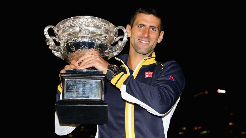Novak Djokovic of Serbia celebrates with the Norman Brookes Challenge Cup at Melbourne Park.